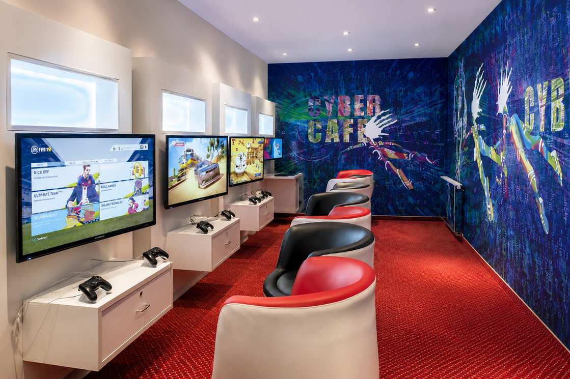 Cyber cafe gaming lounge with multiple screens and red chairs